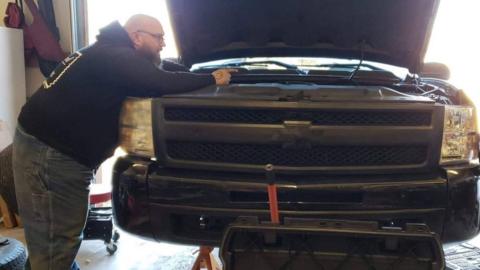 Adam looking at the inside of a car bonnet