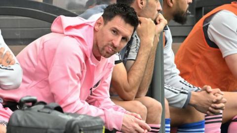 Lionel Messi sits on the bench