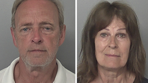 Side-by-side police headshots of Paul Cotson and Stephanie Cotson. Paul Cotson is short grey hair and is wearing a white polo shirt. Stephanie Cotson has shoulder-length brown hair and is wearing a black top. The wall behind them both is grey. 