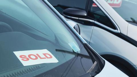 Car with a sold sign in the window