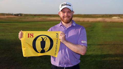 Nathan Kimsey poses with a pin flag after qualifying for the Open during final qualifying