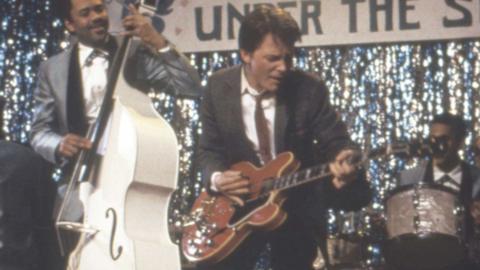 Michael J. Fox as Marty McFly playing a guitar in Back to the Future, 