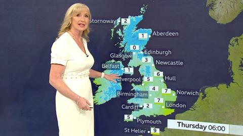 Carol Kirkwood presenting the weather stood in front of a map of the UK.