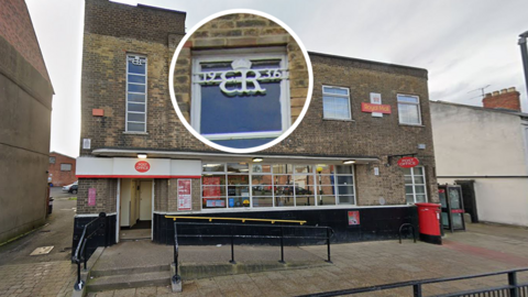 The Post Office branch on Chester-le-Street's Front Street. The building is Art Deco-style made of brown brick and has a modern Post Office signage outside in red and white. The cypher, which is white, is on top of the building. It has a crown above it and reads 19 ER 36 with the Roman numerals VIII under it. It has also been pulled out of the picture to show its prominence.