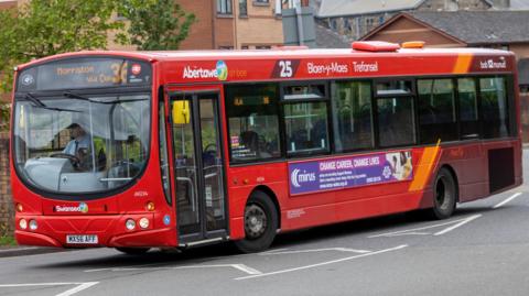 A red bus on a road.