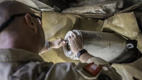 An UNMAS mine clearance expert inspecting a bomb in West Mosul