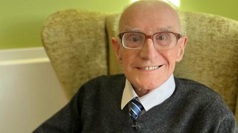 Archie McQuater sitting in his chair in the care home