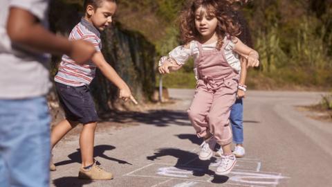 Children playing hopscotch in the street