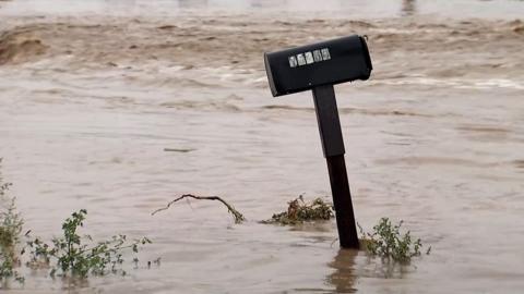 A mailbox surrounded by floodwaters