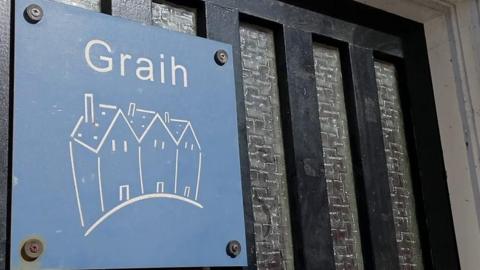 The sign for Graih on the outside door