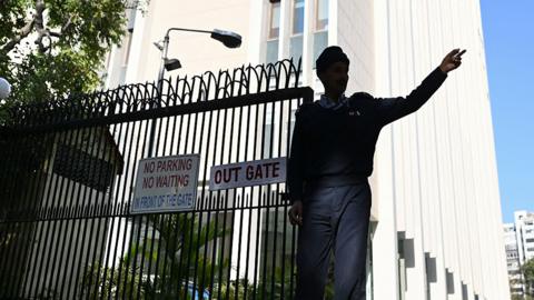 A private security guard gestures at the entrance of the office building where Indian tax authorities raided BBC's office, in New Delhi on February 15, 2023.