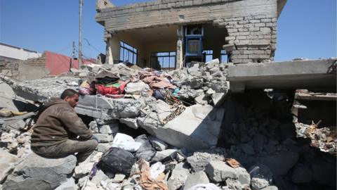 An Iraqi man sits amid the rubble of destroyed houses in Mosul"s al-Jadida area on March 26, 2017, following air strikes in which civilians have been reportedly killed during an ongoing offensive against the Islamic State (IS) group