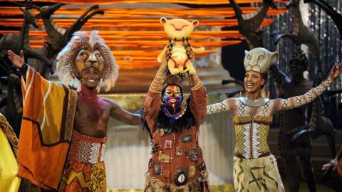 actors perform in the Lion King stage show.
