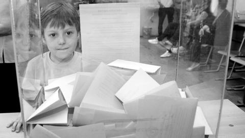 A child looks into a ballot box