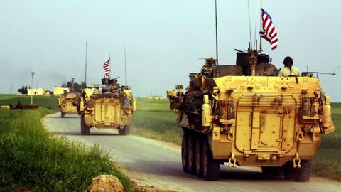 US forces accompanied by YPG fighters drive their armoured vehicles in northern Syria in April 2017