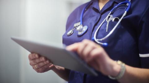 Nurse pictured holding a tablet