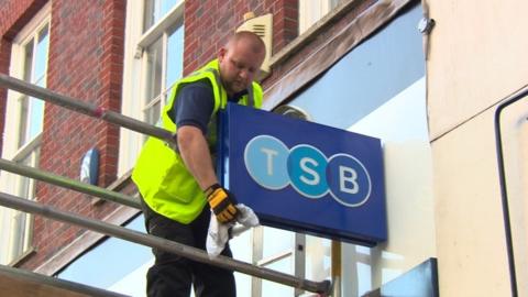 Man cleaning TSB sign