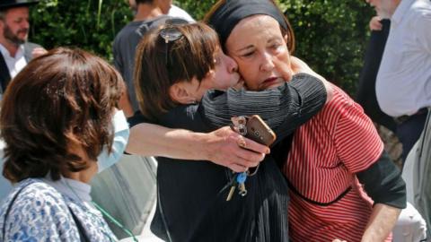 An Ultra-Orthodox Jewish woman comforts another at a cemetery in Benei Brak, 30 April