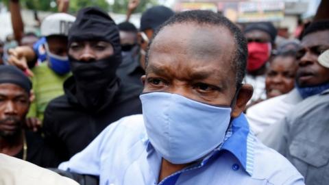Yves Jean-Bart, president of the Haitian Football Federation, wearing a protective face mask arrives at his hearing at the Crois-Des-Bouquets prosecutor"s office