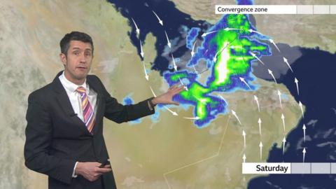 Chris Fawkes stands in front of a weather map of the Middle East