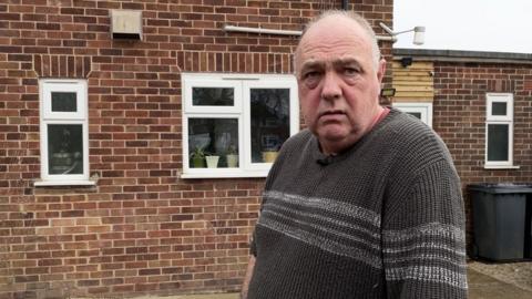 Ian Miller standing outside his council house in Holbeach