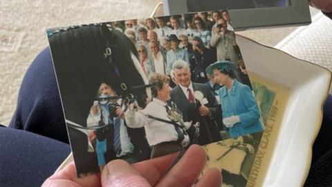Clare Christian holding a photo of the Queen's visit in 1989
