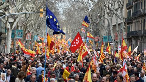 People hold Spanish and EU flags during a pro-unity rally organised by the Tabarnia movement, a fictional region that wants independence from Catalonia, on 4 March 2018 in Barcelona