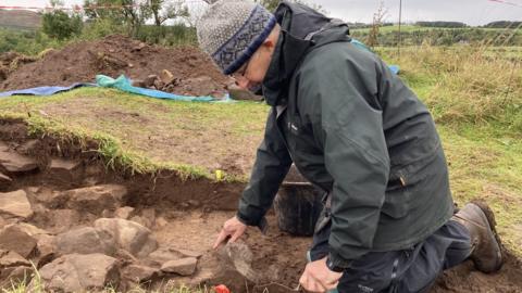 Archaeologists uncovering the walls of Bedrule Castle.