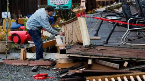 A man inspects a damaged building