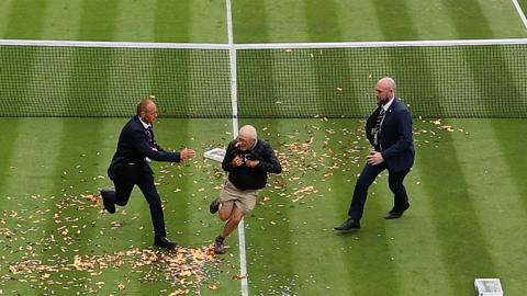 Just Stop Oil protester runs onto one of the courts at Wimbledon