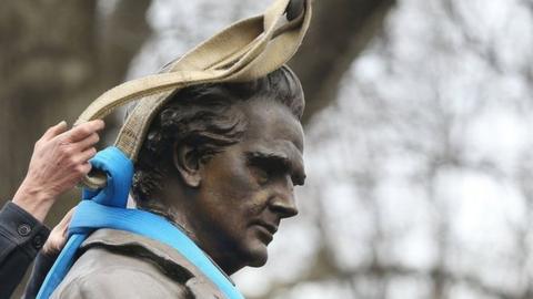 A worker secures the statue of J. Marion Sims before it is driven away, 17 April 2018