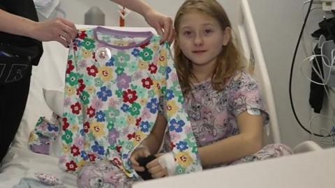 Hospital patient Eva with a pair of gifted pyjamas
