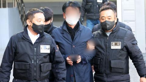 A 67-year-old realty broker is taken to attend a review of his arrest warrant at the Busan District Court, South Korea, 4 January 2023