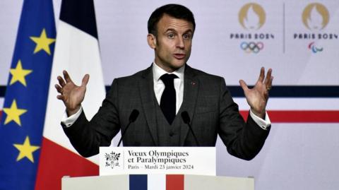 French President Emmanuel Macron gestures with his hands as he gives a speech
