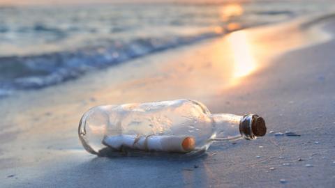 A bottle on a beach, with a note inside