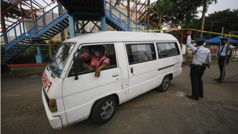 Funeral workers transport the body of a shooting victim at a university in Quezon City, Metro Manila, Philippines, 24 July 2022.