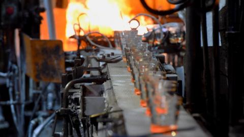 glasses on a conveyor belt to a furnace