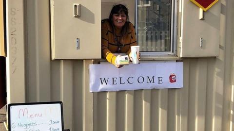 worker at makeshift drive-through burger par