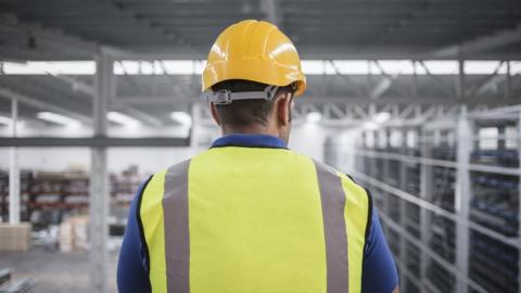 Factory worker in hard hat and reflective jacket