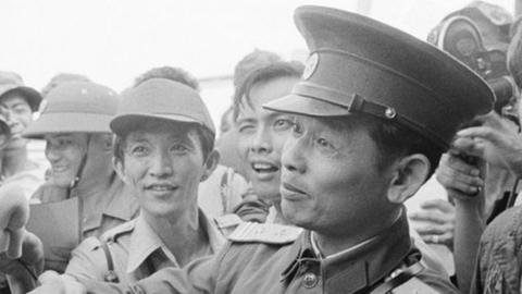 N. Vietnamese Lt. Col. Bui Tin (r), official spokesman for the N. Vietnamese delegation to the JMC, shakes hands with unidentified American Airforce SGT