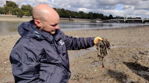 Volunteer holds up discarded wet wipes