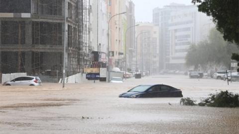 Cars are seen abandoned on a flooded street