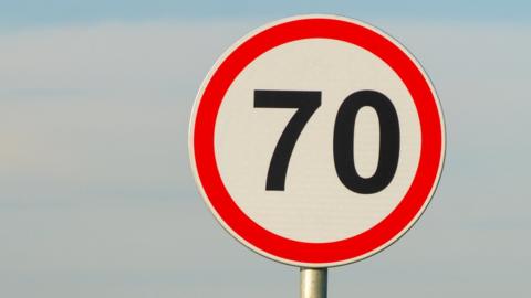 A 70mph sign with blue sky in the background