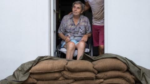 Parramatta Park resident John Irving and his son Steve look at the sky from their sandbagged doorway in Cairns, Queensland, on 15 December 2018.