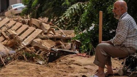 Man sitting down looking at flood devastation