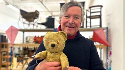 Alan Powers holding a historic teddy bear.