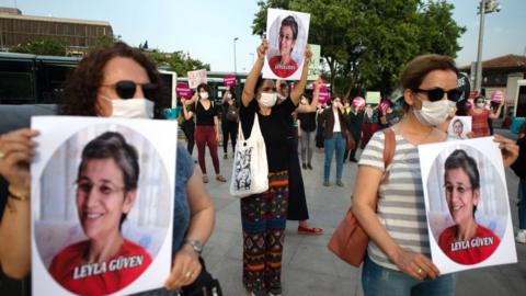 Demonstrators hold pictures of HDP lawmaker Leyla Guven