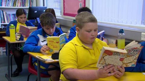 Children reading books in a classroom