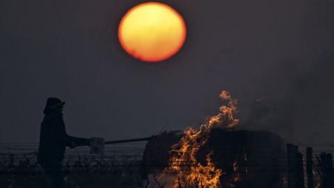 A winegrower burns a bale of straw in the vineyards to protect them from frost on 7 April,2021, Vouvray vineyard in Touraine.