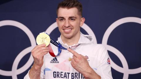 Max Whitlock pointing at his gold medal